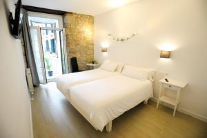 圣塞瓦斯蒂安Artea Narrika的卧室设有一张白色大床和一扇窗户。