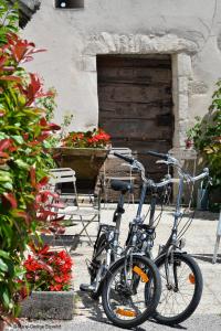 爱斯科利夫-圣卡米博格南特地区酒店的两辆自行车停在一座鲜花盛开的建筑前