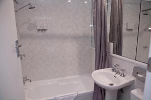 悉尼沙威双湾酒店 的浴室配有盥洗盆、卫生间、浴缸和盥洗盆。