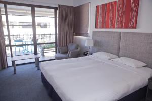 悉尼沙威双湾酒店 的酒店客房带一张大床和一把椅子