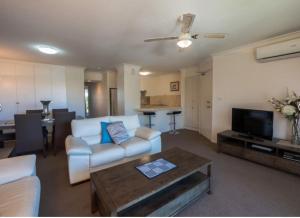 黄金海岸海景沃特斯公寓的客厅配有沙发和桌子