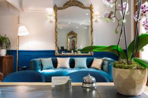 巴黎莫加多尔酒店的客厅配有蓝色沙发,设有镜子