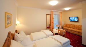 翁特陶埃恩Hotel Hammerwirt - Forellenhof的酒店客房,设有两张床和一张沙发