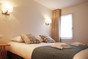 巴黎圣安娜花园公寓的酒店客房,配有带毛巾的床