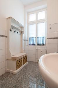 瓦尔内明德Ferienwohnung Warnemünde - L (N)的白色的浴室设有浴缸和水槽。