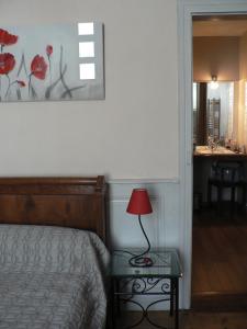 米格龙La Terrasse de la Grand'Rue - chambre d'hôtes -的一间卧室配有一张床和一张带台灯的桌子