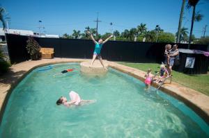 麦凯清凉棕榈汽车旅馆的女人跳进游泳池