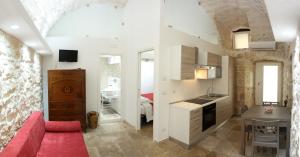 莫尔费塔Lilla B&B Luxury Apartments的一间带红色沙发的客厅和一间厨房