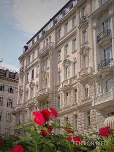 维也纳雷德尔旅馆的一座白色的大建筑,前面有红花