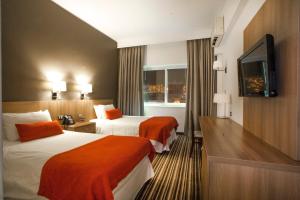 安托法加斯塔Hotel Antofagasta的酒店客房设有两张床和一台平面电视。