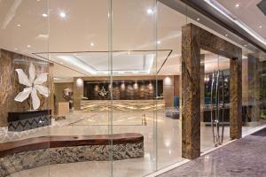 雅加达艾亚柯套房酒店的带有玻璃墙的酒店大厅