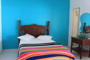 里约热内卢Hostel Vista do Mar的一间卧室配有一张蓝色墙壁的床