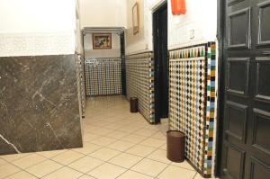卡萨布兰卡博斯坦酒店的浴室的走廊设有门,铺有瓷砖地板