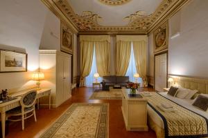 佛罗伦萨奎恰尔迪尼宫殿酒店的一间卧室配有一张床、一张桌子和一张沙发