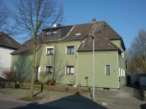 埃森Ferienwohnung Laux的棕色屋顶的绿色房子