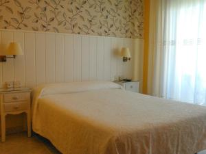巴约讷Hostal Santa Marta Playa的卧室配有白色的床和窗户。