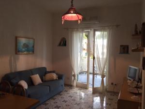 伊斯基亚Santa Caterina的客厅设有蓝色的沙发和滑动玻璃门