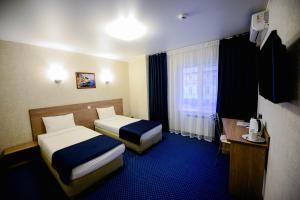 喀山阿隆酒店的酒店客房设有两张床和窗户。