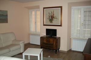 加尔达湖滨Residenza Porte Vecchie的客厅配有沙发和桌子上的电视