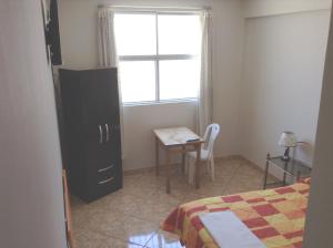 纳斯卡Hospedaje el Telar的一间卧室配有一张床、一张桌子和一个窗户。