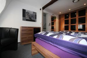 摩泽尔河畔的泽尔Ferienhaus DaVinci的一间卧室配有一张床和一张黑椅