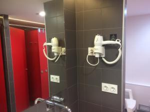 潘普洛纳伊瓦罗拉旅舍的浴室设有淋浴、镜子和红色摊位
