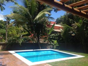 阿拉亚尔达茹达D'ajuda Flat的棕榈树屋前的游泳池