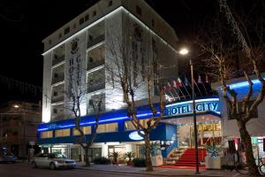 蒙特西尔瓦诺城市酒店的上面有蓝色 ⁇ 虹灯标志的酒店大楼