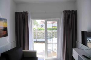 英格兰海滩Bungalows Los Arcos的客厅设有滑动玻璃门,可通往庭院