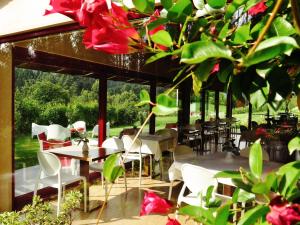 圣马尔塔奥尔蒂盖拉Hotel El Castaño Dormilón的一间设有白色桌椅和红色鲜花的餐厅
