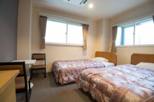 奈良天平旅馆的酒店客房设有两张床、一张书桌和两个窗户。