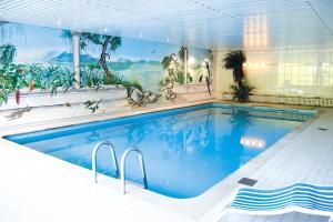 艾托弗斯胡森赫夫酒店的墙上挂有壁画的大型游泳池