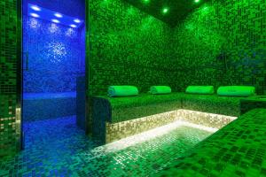 罗马阿特米德酒店的带浴缸的客房,配有绿色和蓝色的灯光