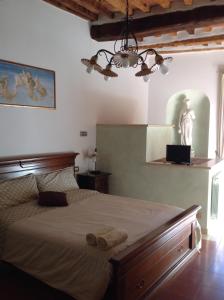 拉波拉诺泰尔梅Relax Centro storico的卧室配有一张大床,墙上挂着雕像