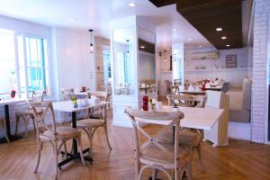 莱卡邦At Residence Suvarnabhumi Hotel - SHA Extra Plus的餐厅设有白色的桌椅和柜台