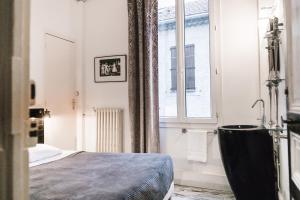 戛纳尚特克莱尔酒店的浴室设有床、水槽和窗户。