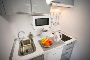 科拉雷侯Corralejo Lodge的一个带水槽和一碗水果的小厨房
