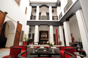 马拉喀什里亚德达阿森旅馆的客厅配有红色椅子和桌子