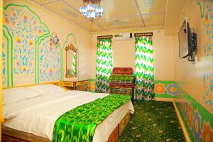 塔什干HON SAROY - immerse atmosphere in the epoch of the khans的卧室配有一张床铺,位于拥有色彩缤纷的墙壁的房间