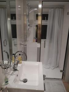 温莎鲁特兰兹住宿加早餐旅馆的浴室配有白色水槽和淋浴。