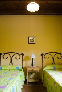 马拉加马拉加蒙特斯乡村民宿 - 佩德格尔斯农场的一间卧室配有两张床和一张带台灯的桌子