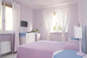 马里纳-迪-皮特拉桑塔Villa Amelia Rooms的一间白色卧室,配有床和2个窗户