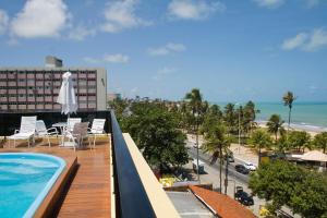 若昂佩索阿布兰科公寓式酒店的阳台设有游泳池,享有海滩美景