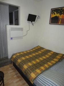 巴塞罗那拉西欧旅馆的卧室配有一张床铺,墙上挂着毯子