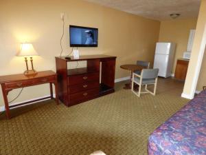 圣乔治经济套房酒店的酒店客房设有一张床和一个带电视的梳妆台
