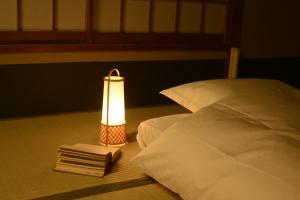 京都京都满月住宿加早餐旅馆的一张带灯和书架的床
