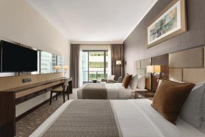 阿布扎比Hawthorn Extended Stay by Wyndham Abu Dhabi City Center的酒店客房设有两张床和一台平面电视。