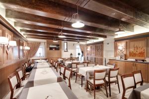 莱沃恰Penzion Kiska Levoča的用餐室设有白色桌子和木墙