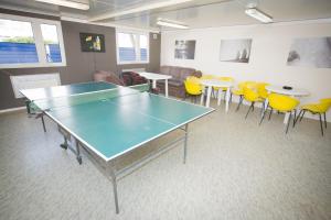 华沙新城旅舍的配有乒乓球桌和椅子的房间