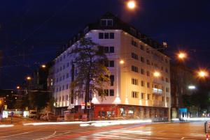 杜塞尔多夫Studiotel Belle Etage的夜行的街道上一座白色的大建筑